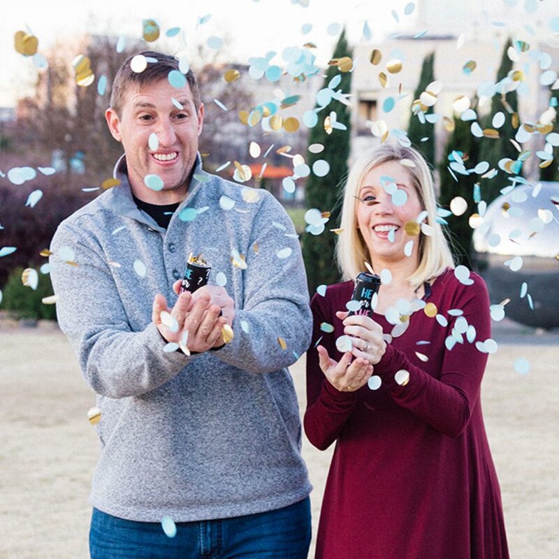 Couple using gender reveal poppers for boy