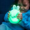 Girl Squeezing LumiPets Bunny Nightlight with Remote and Bluetooth
