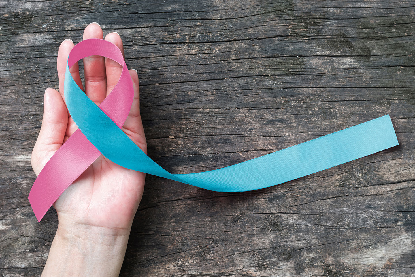 A Woman's Hand Holding a Pregnancy Loss Awareness Ribbon